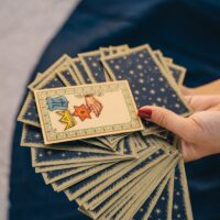 A hand holding a spread of tarot cards, symbolizing mysticism and spirituality.